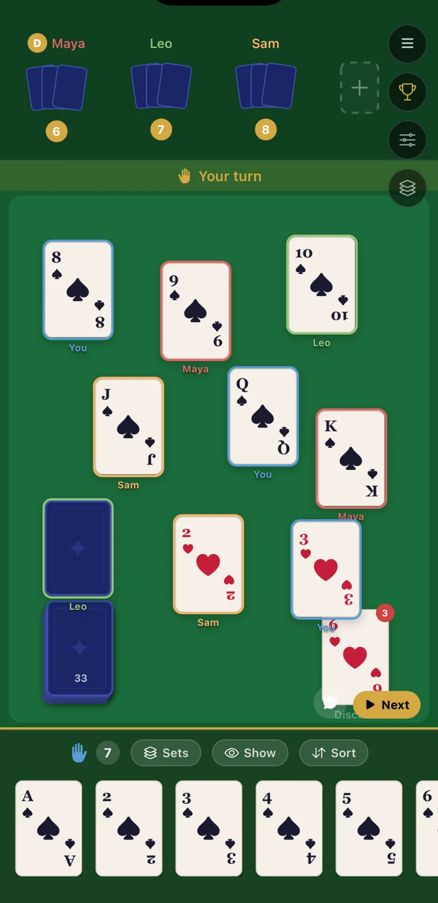 A game in progress: cards on the felt, player hands along the bottom, deck and discard pile.
